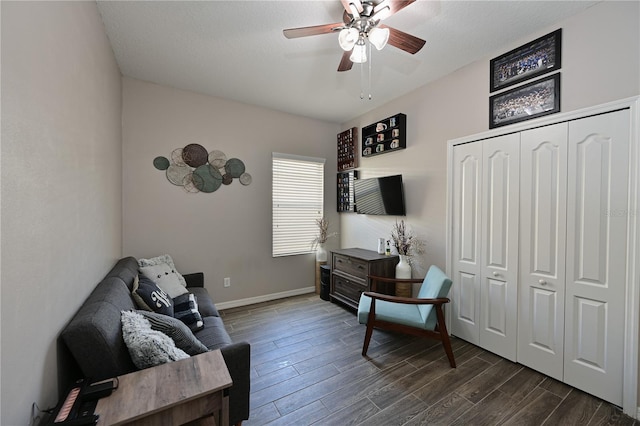 sitting room with dark wood-type flooring, a textured ceiling, and ceiling fan