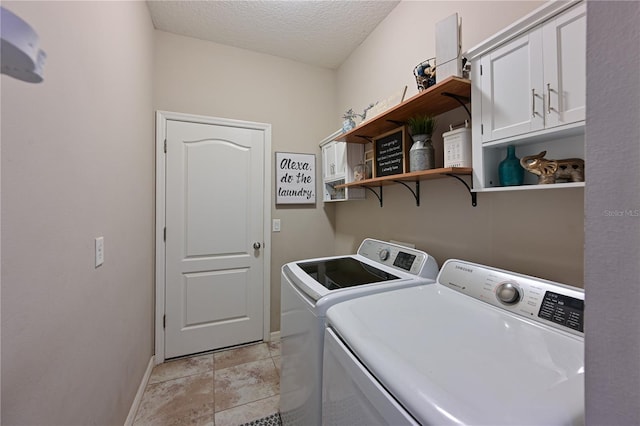 washroom featuring cabinets, separate washer and dryer, a textured ceiling, and light tile patterned floors