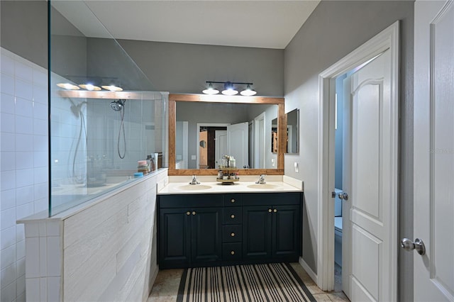 bathroom with a tile shower, vanity, and toilet