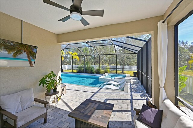 view of pool with a lanai, an outdoor hangout area, a patio, and ceiling fan