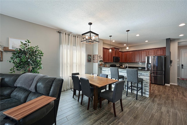 dining room featuring dark wood-type flooring and a textured ceiling