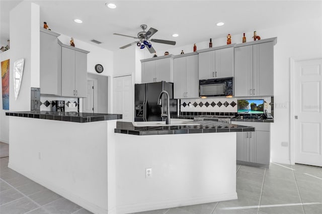 kitchen with sink, gray cabinets, black appliances, and kitchen peninsula