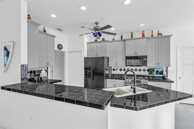 kitchen featuring sink, gray cabinetry, tile countertops, kitchen peninsula, and black appliances