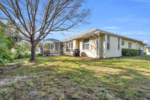 exterior space with glass enclosure and a lawn