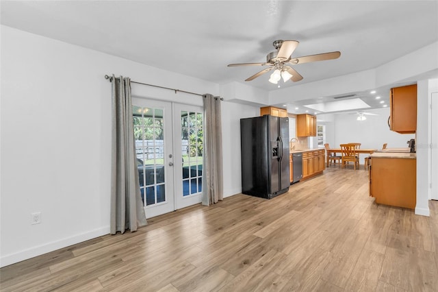 kitchen featuring stainless steel dishwasher, ceiling fan, light hardwood / wood-style floors, black refrigerator with ice dispenser, and french doors