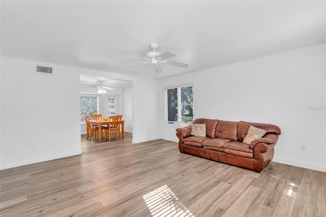 living room with ceiling fan and light hardwood / wood-style flooring