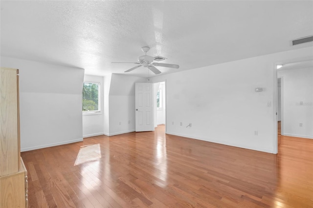 unfurnished room featuring ceiling fan, a textured ceiling, and light hardwood / wood-style flooring