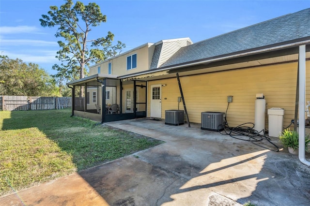 rear view of property with cooling unit, a yard, a sunroom, and a patio