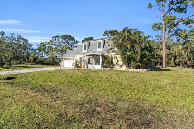 view of front of property featuring a garage, a sunroom, and a front yard