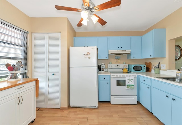 kitchen featuring blue cabinets, white appliances, and light hardwood / wood-style flooring