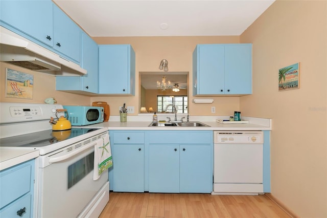 kitchen with sink, white appliances, hanging light fixtures, and blue cabinets