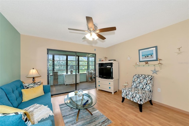 living room featuring ceiling fan, a textured ceiling, and light hardwood / wood-style flooring