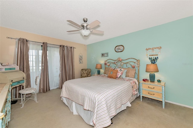 carpeted bedroom featuring ceiling fan and a textured ceiling