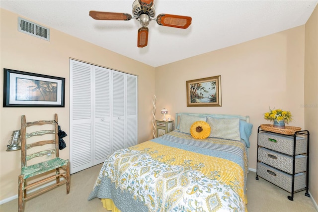 carpeted bedroom featuring ceiling fan and a closet