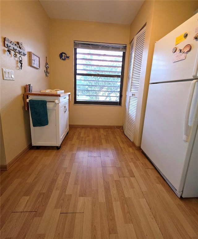 535 Spring Lakes Blvd, Bradenton, FL 34210 - kitchen with freestanding refrigerator, light wood-style floors, and white cabinetry