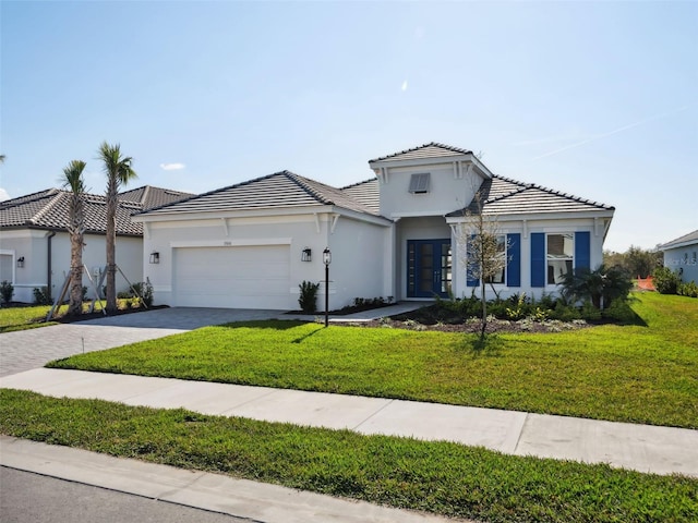 mediterranean / spanish-style home featuring a garage and a front lawn