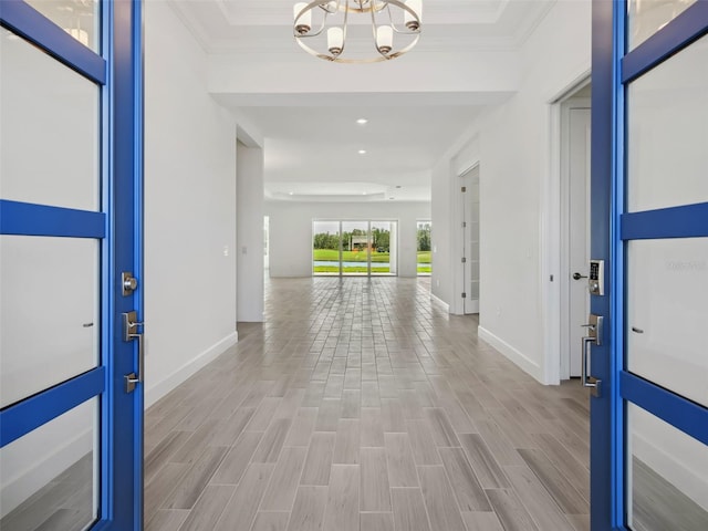 entrance foyer featuring ornamental molding, a notable chandelier, and light hardwood / wood-style flooring