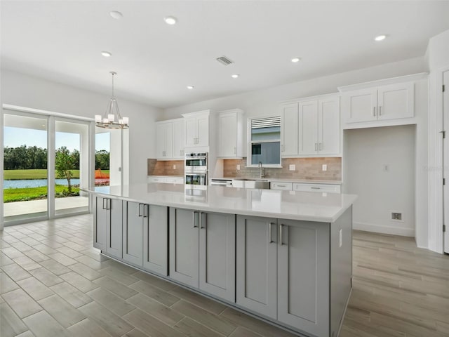 kitchen with white cabinetry, a large island, and decorative backsplash