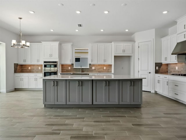 kitchen featuring gray cabinetry, stainless steel appliances, and white cabinets