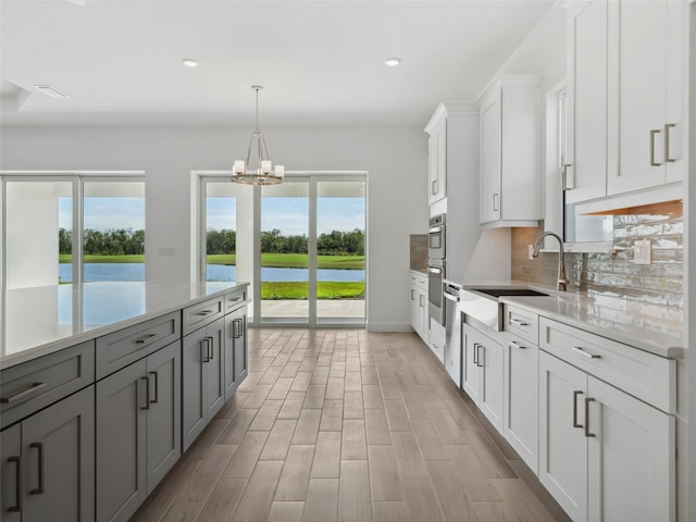 kitchen featuring gray cabinetry, sink, tasteful backsplash, and white cabinets