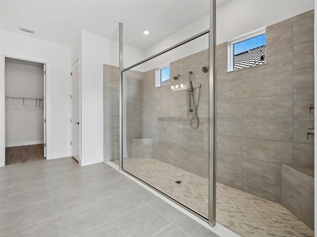 bathroom featuring tiled shower and tile patterned floors