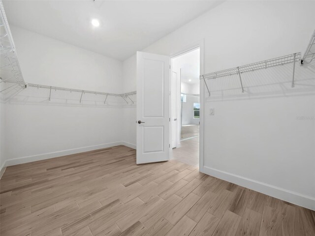 walk in closet with light hardwood / wood-style floors