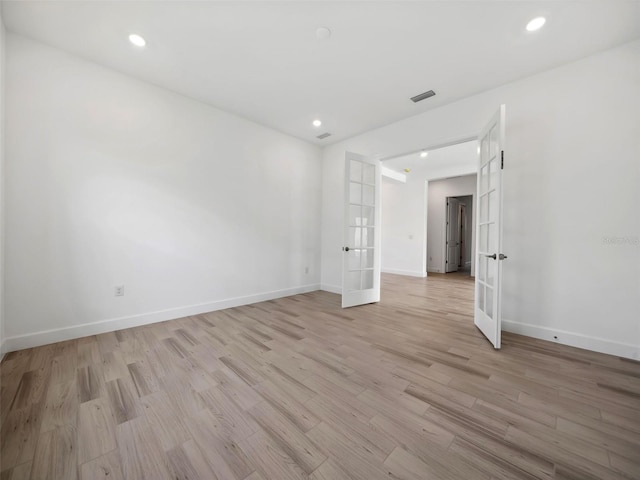 spare room featuring light hardwood / wood-style floors and french doors