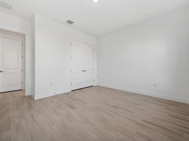 unfurnished bedroom with a closet and light hardwood / wood-style flooring