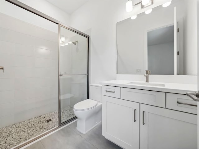 bathroom featuring tile patterned flooring, walk in shower, vanity, and toilet