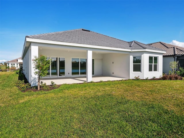 rear view of house featuring a yard and a patio