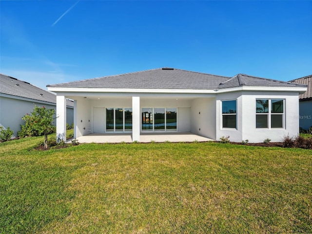 rear view of house with a yard and a patio