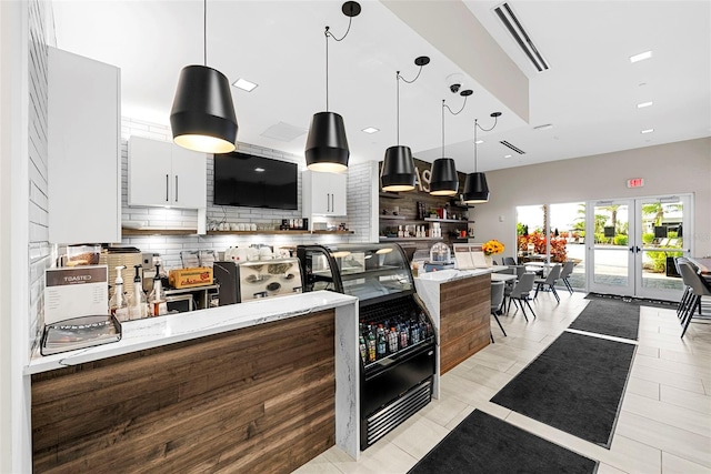 kitchen featuring white cabinetry, light stone counters, and decorative backsplash