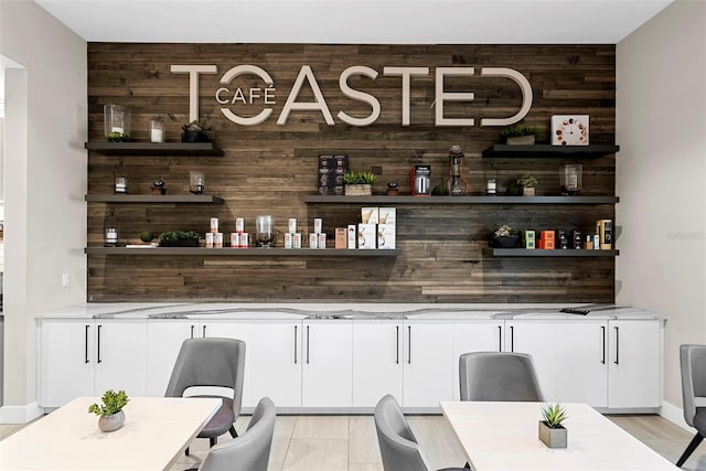 bar with wooden walls and white cabinets