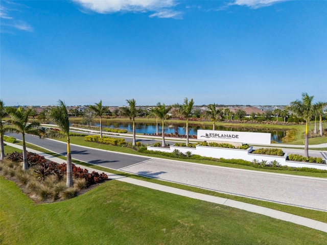 view of home's community with a water view and a lawn