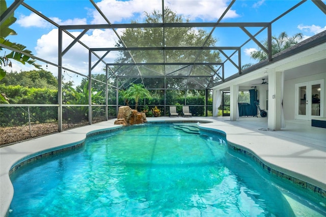 view of pool featuring a patio, ceiling fan, glass enclosure, and french doors