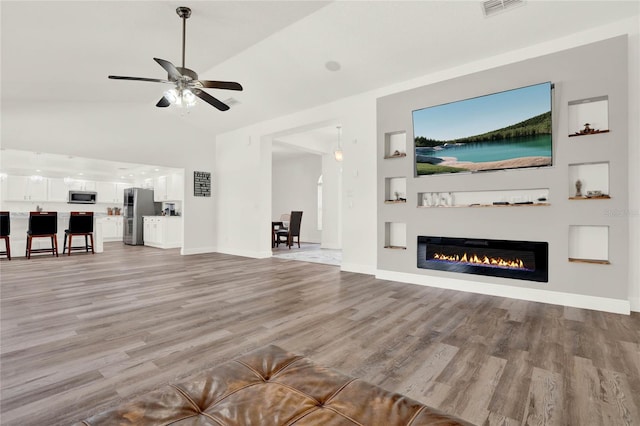 unfurnished living room with high vaulted ceiling, ceiling fan, and light hardwood / wood-style flooring