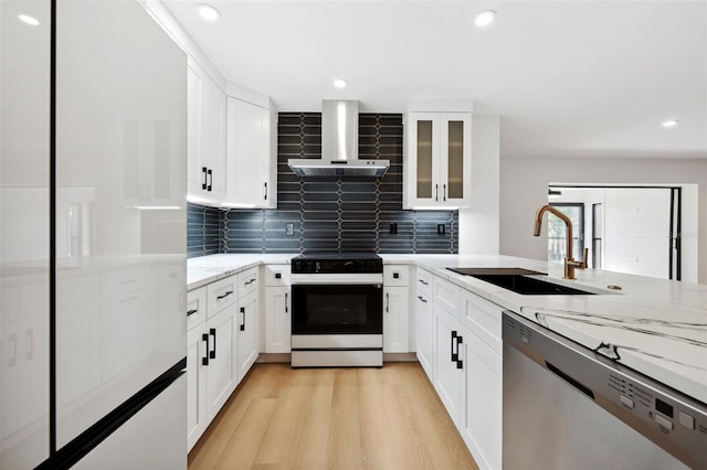 kitchen with sink, electric range oven, stainless steel dishwasher, light stone countertops, and wall chimney range hood