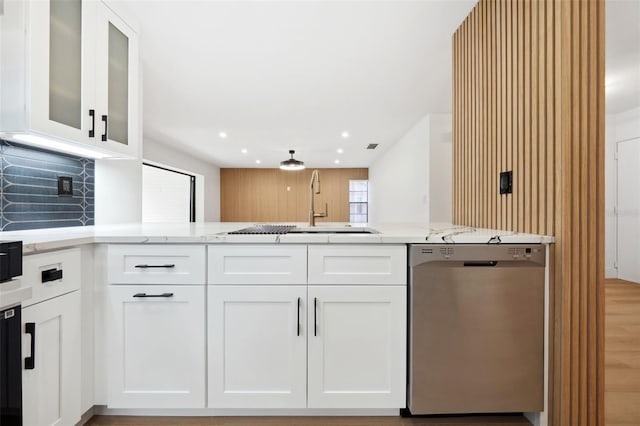 kitchen featuring light stone counters, white cabinets, kitchen peninsula, and dishwasher