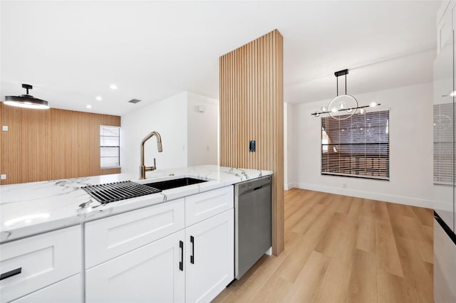 kitchen with white cabinetry, hanging light fixtures, stainless steel dishwasher, light hardwood / wood-style floors, and light stone countertops