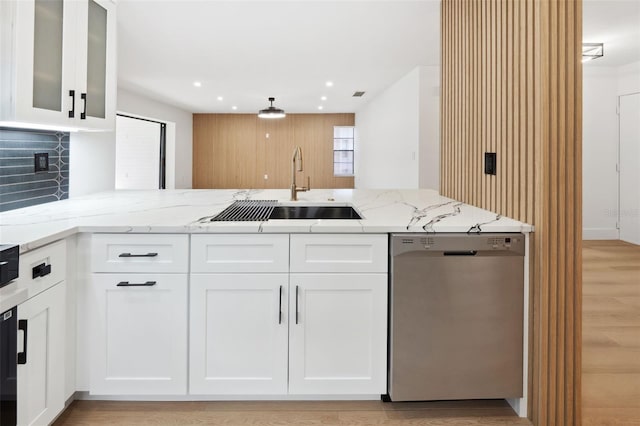 kitchen featuring sink, light stone counters, stainless steel dishwasher, kitchen peninsula, and white cabinets