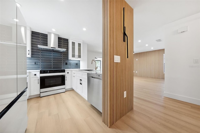 kitchen with wall chimney exhaust hood, sink, white cabinetry, electric range, and dishwasher