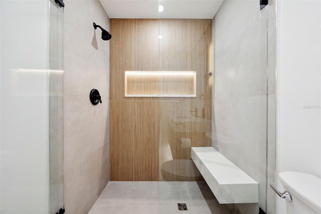 bathroom featuring a tile shower and toilet