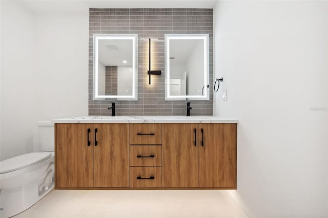 bathroom featuring tasteful backsplash, vanity, and toilet