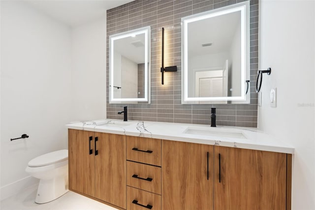 bathroom with vanity, toilet, tile patterned floors, and decorative backsplash