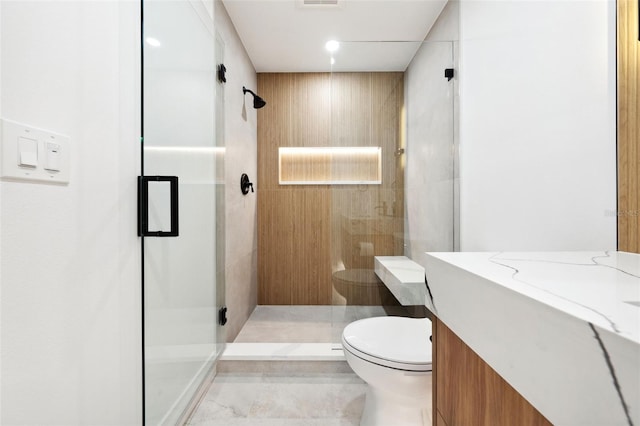 bathroom featuring vanity, an enclosed shower, and toilet