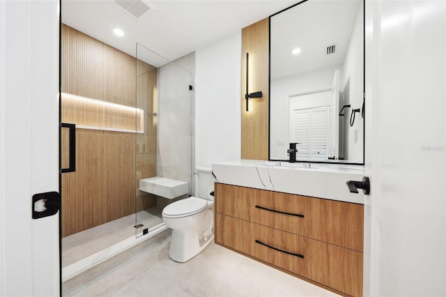 bathroom with vanity, toilet, and a shower with shower door