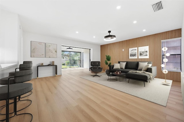 living room featuring wooden walls and light wood-type flooring