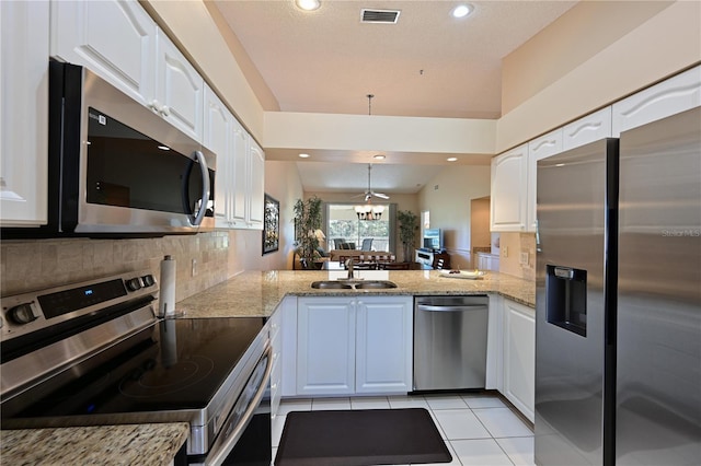 kitchen with sink, stainless steel appliances, kitchen peninsula, and white cabinets