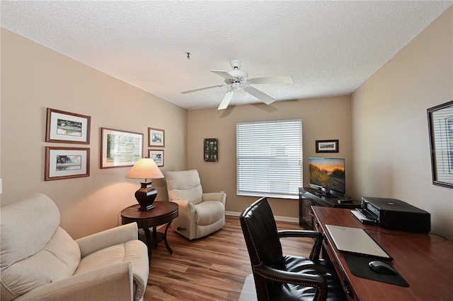 home office featuring a textured ceiling, ceiling fan, and light wood-type flooring