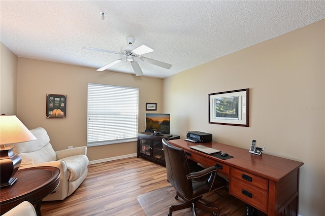 home office with ceiling fan, a textured ceiling, and light wood-type flooring